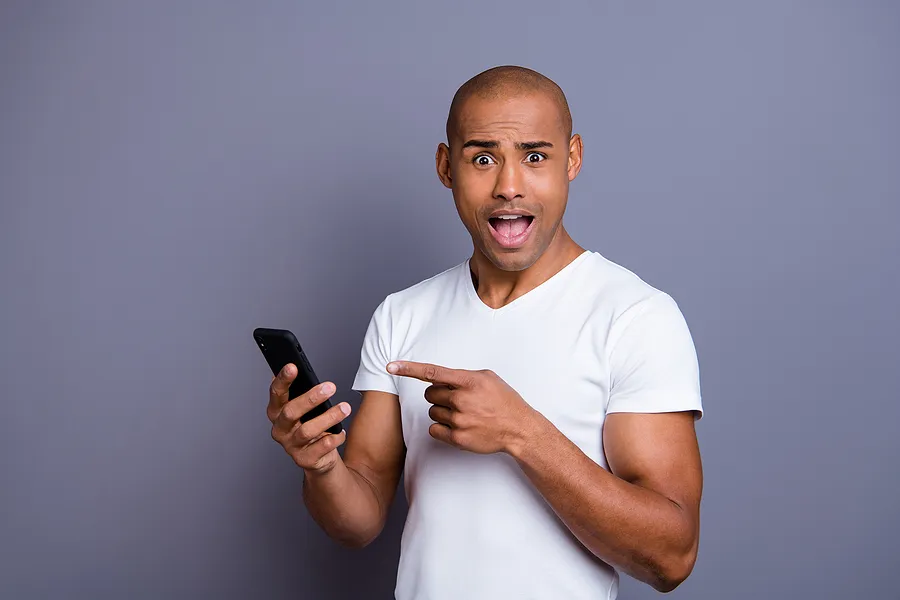 Man holding a mobile phone in surprise