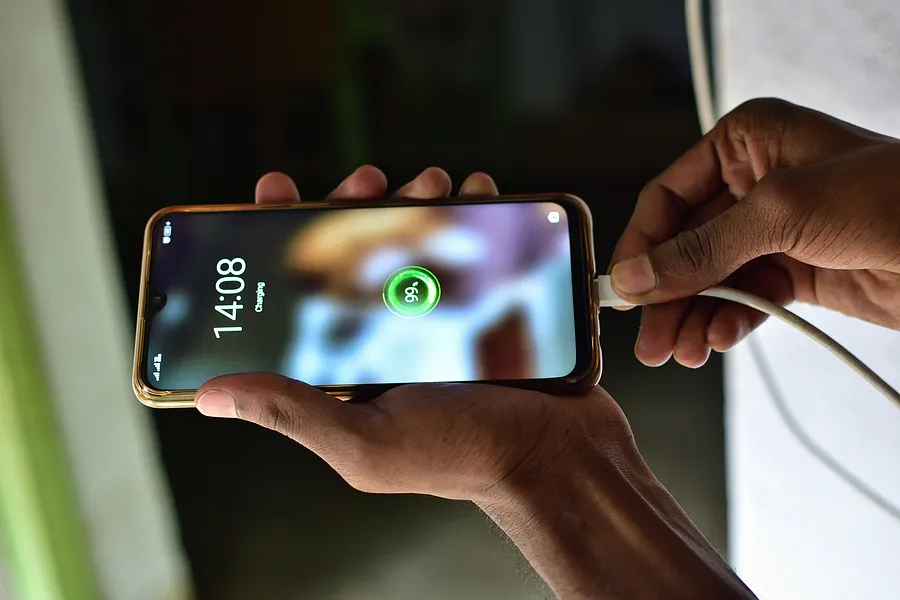 person plugging a smartphone into a charger